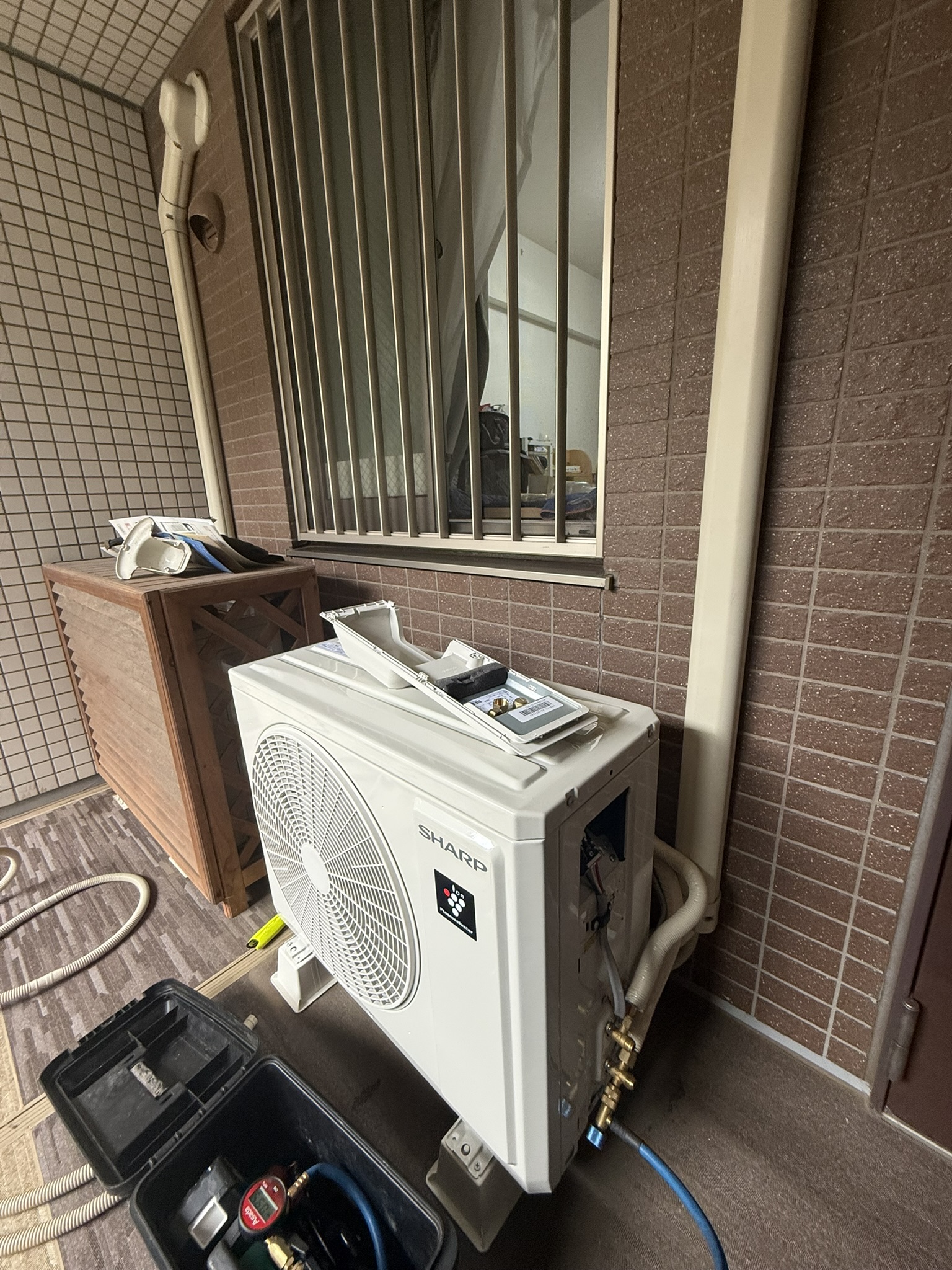 荒川区のマンションで対応したエアコン工事の室外機施工例。ベランダ内へ設置した例。